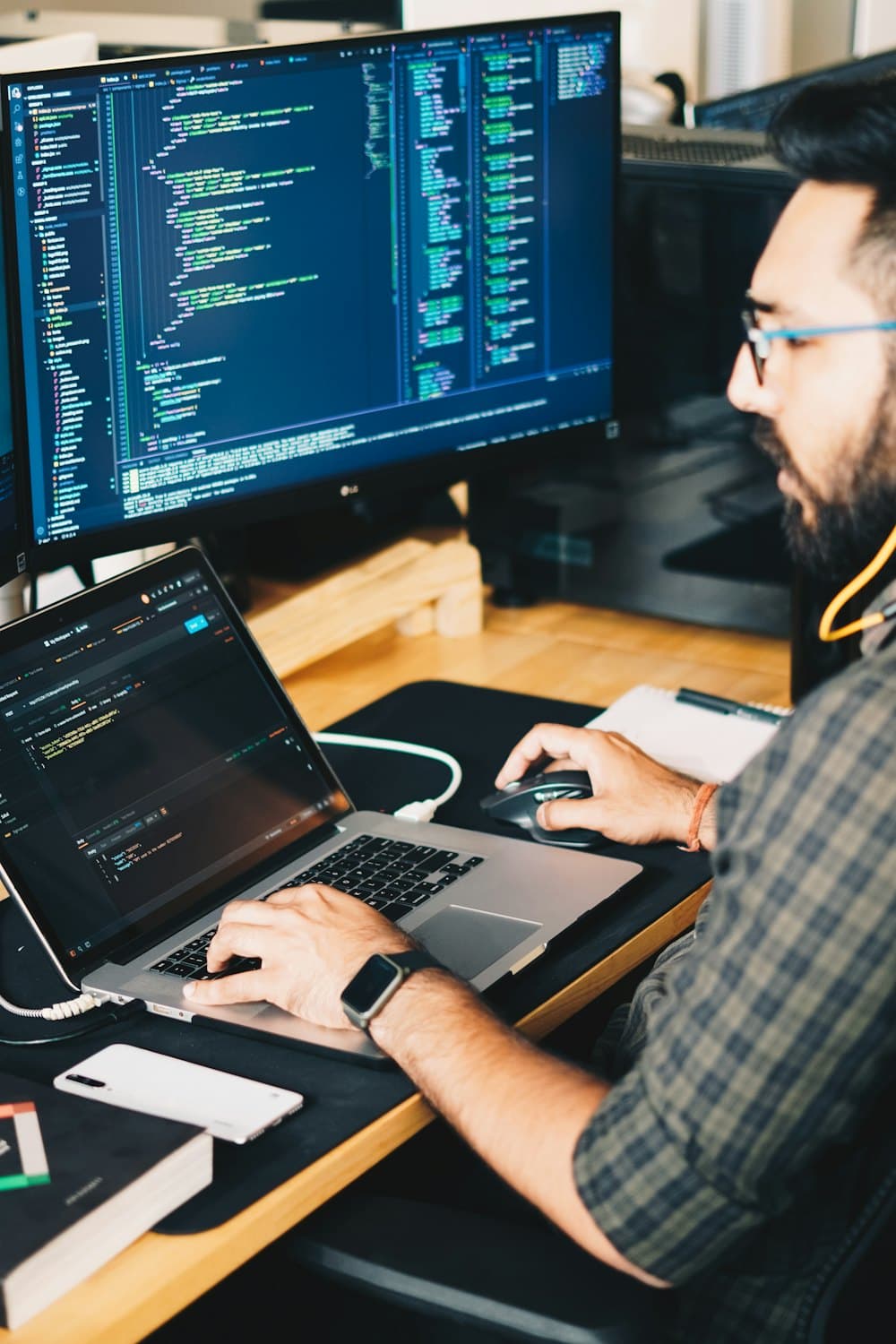 A developer at a desk with two screens of code