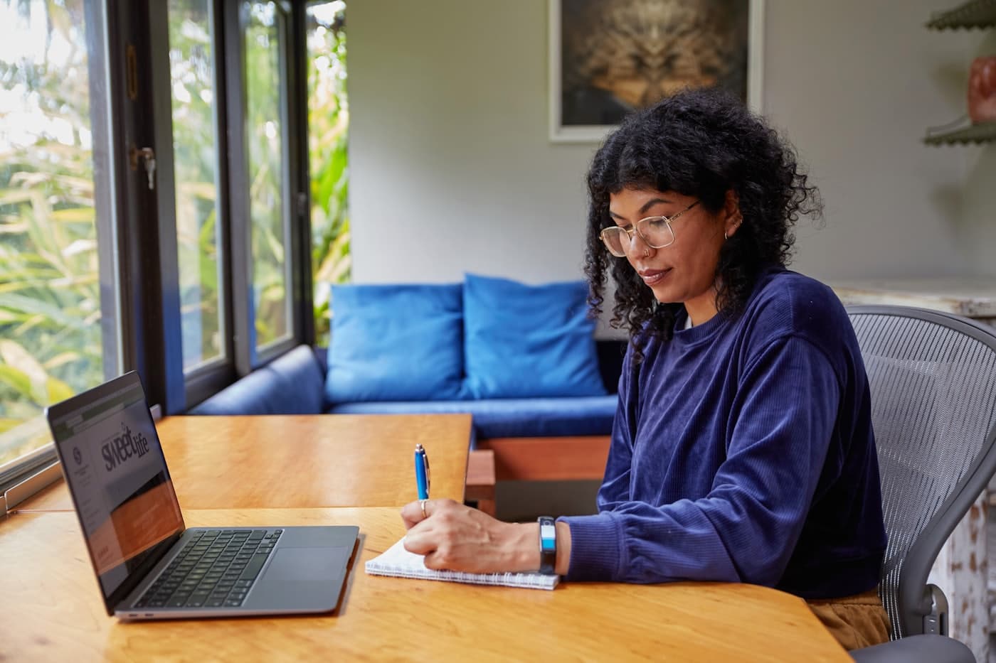A student working through notes beside a laptop